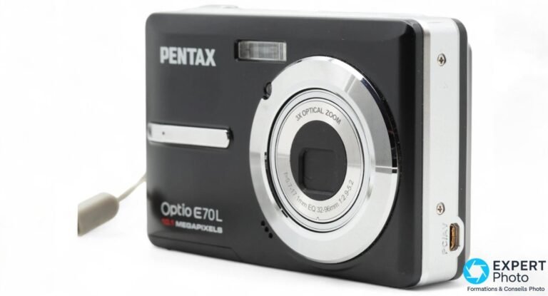 Pentax Optio E70L de trois-quarts avant droit, objectif 3X Optical Zoom sorti, port PC/AV sur la tranche, dragonne.