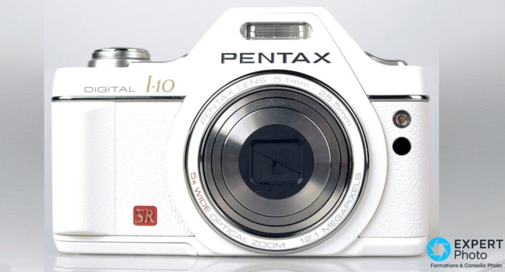 Pentax Optio I-10 blanc face avant studio, objectif rétracté avec volet d'iris fermé, marquage 12.1 MEGAPIXELS.