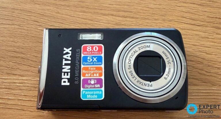 Pentax Optio M50 vu de face, objectif rétracté, autocollants 8 mégapixels, zoom 5x, Face Recognition et Digital SR.