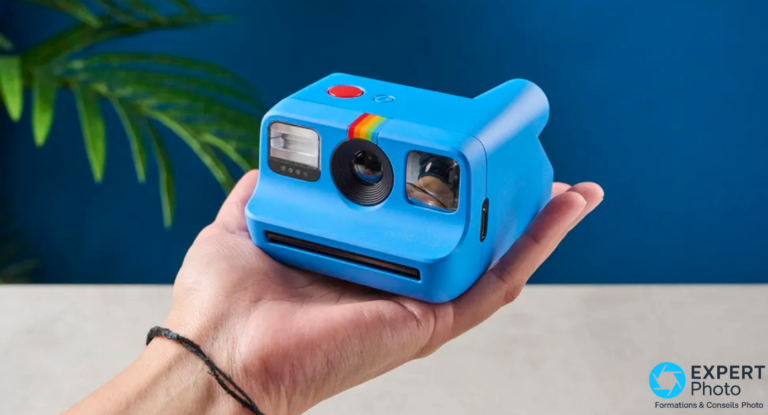 Polaroid Go Gen 2 bleu posé dans la paume d'une main ouverte, fond bleu foncé, taille de poche illustrée