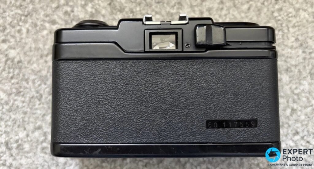 Dos du Ricoh FF-1S fermé, oeilleton de viseur, levier d'avance du film, griffe flash, numéro de série 60 117559