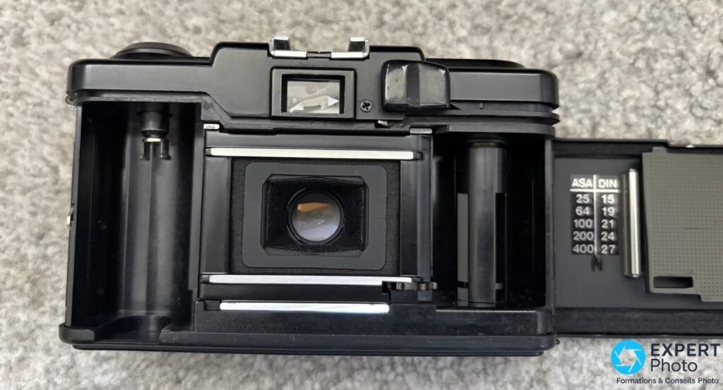 Ricoh FF-1S dos ouvert, chambre intérieure avec rails de fixation et table ASA/DIN gravée sur le rabat
