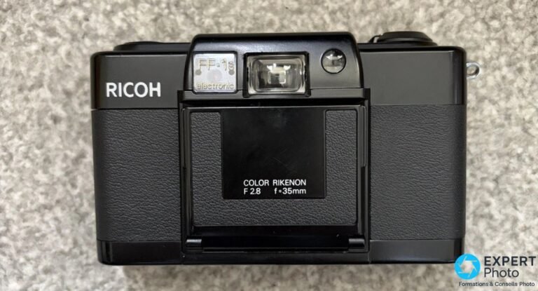 Ricoh FF-1S : un compact argentique à zone focus, pas un AF Compact argentique Ricoh FF-1S noir, face avant, volet rabattable fermé portant les gravures COLOR RIKENON F 2.8 f=35mm