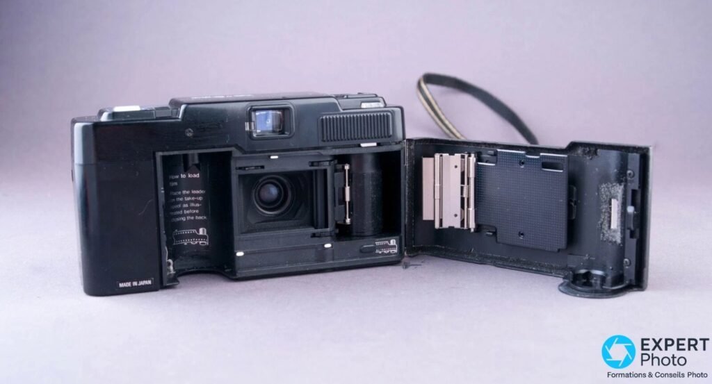 Ricoh FF-3 AF Super noir, dos arrière ouvert sur la droite, compartiment film et logement piles visibles.