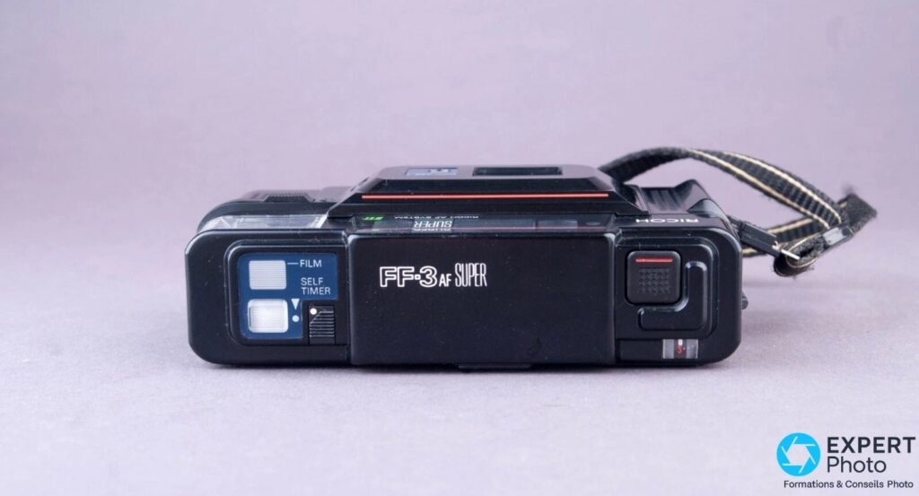  Ricoh FF-3 AF Super vu de dessus, marquage FF-3 AF SUPER lisible, boutons FILM et SELF TIMER visibles.