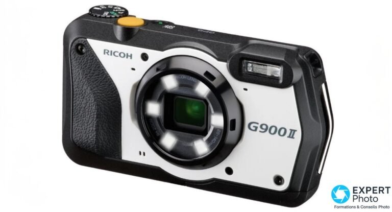 Ricoh G900 II en trois-quarts avant gauche : façade noir et blanc, anneau de six LED allumées et déclencheur jaune.
