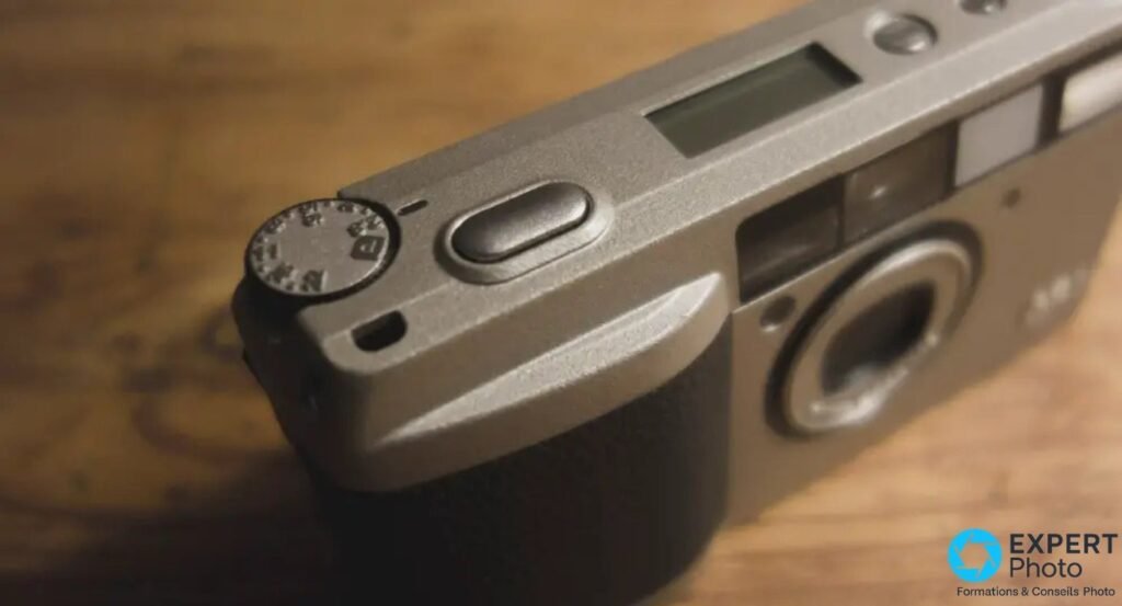  Vue rapprochée du dessus du Ricoh GR1 montrant le déclencheur, la molette de modes et le LCD à segments.