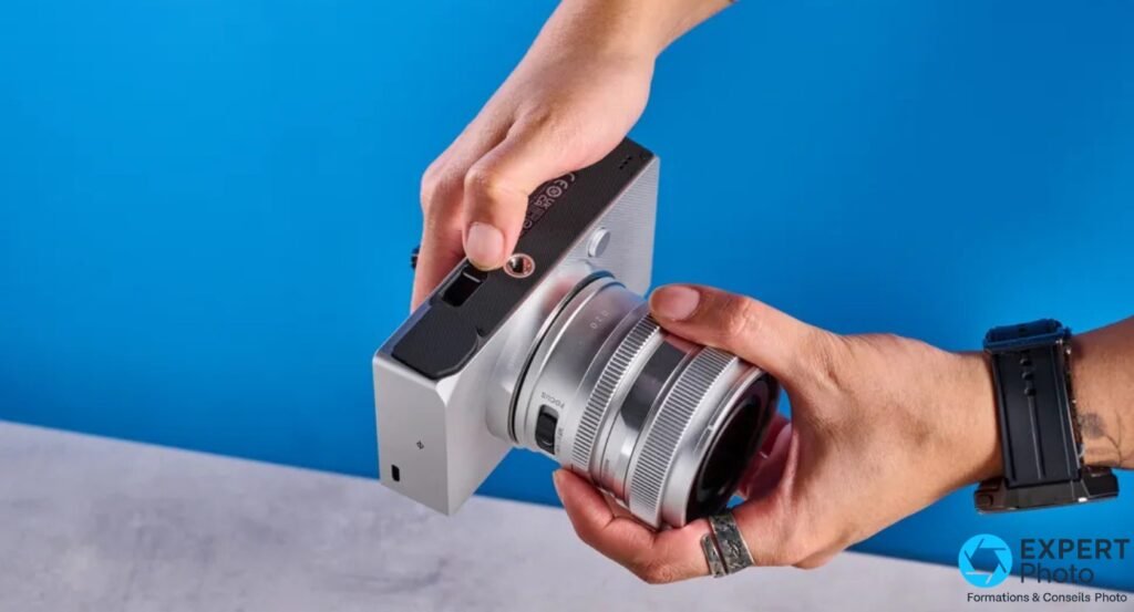 Sigma BF argenté tenu à deux mains en plongée, garniture sombre sur dessus, port USB-C visible sur le flanc
