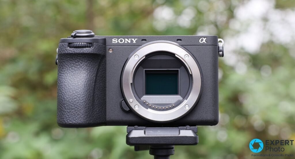 Sony A6700 sans objectif vu de face sur trépied, baïonnette monture E et capteur APS-C apparents.