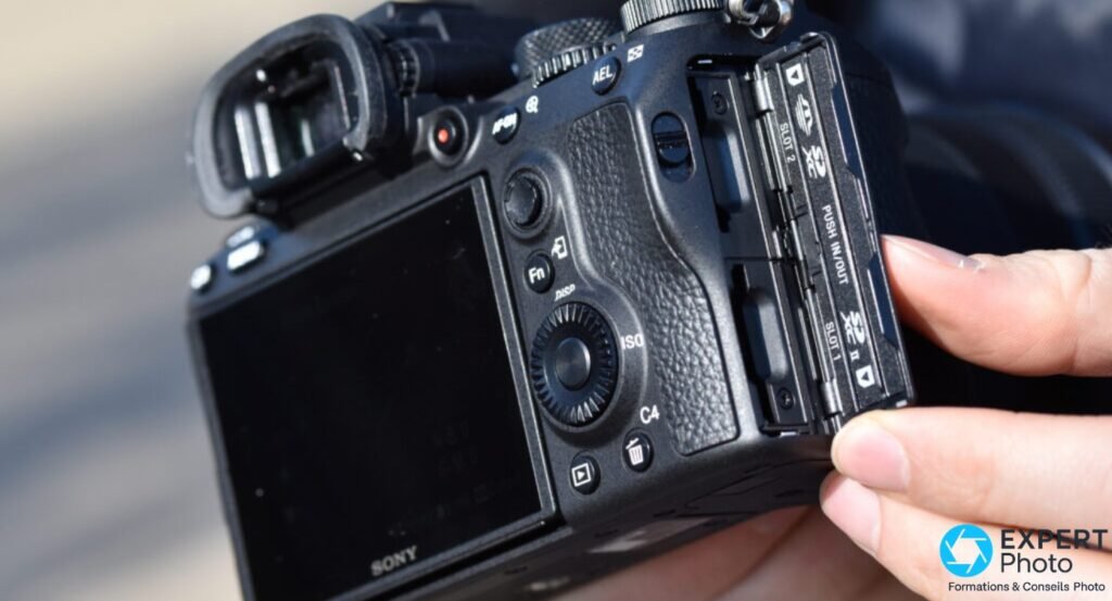 Sony A7 III vu de dos, couvercle double fente SD ouvert, inscriptions SLOT 1 et SLOT 2 lisibles sur les guides de cartes