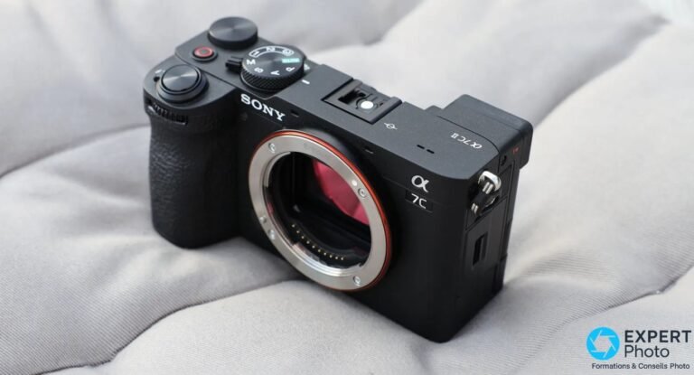Sony A7C II boîtier nu vu de trois quarts avant, monture E exposée et capteur visible, posé sur tissu gris