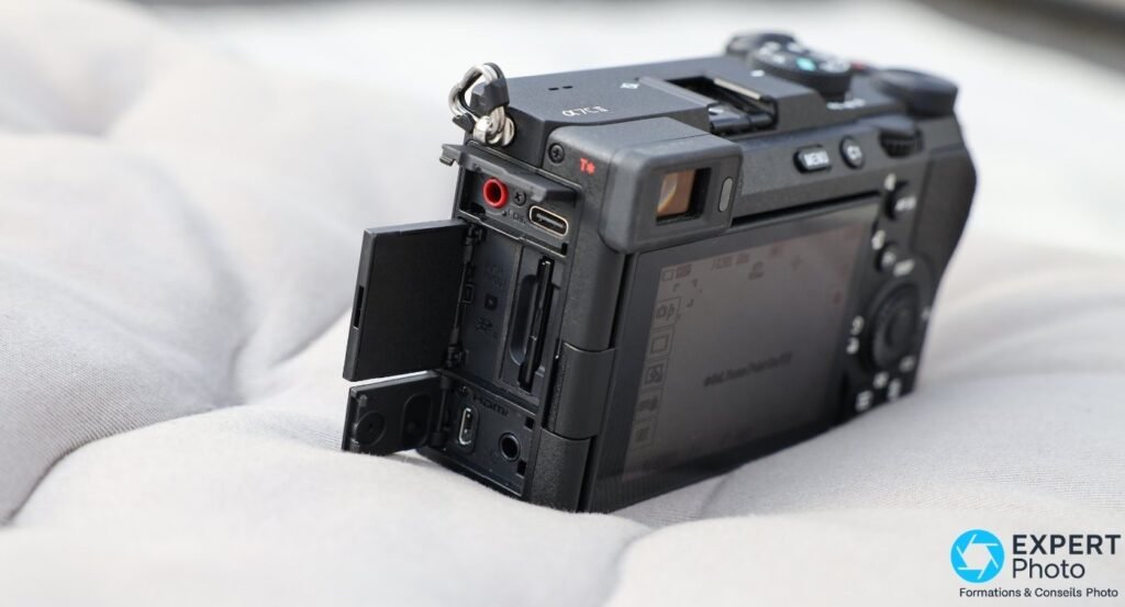 Sony A7C II vu de trois quarts arrière, trappe ouverte montrant slot SD UHS-II unique, port USB-C et prise micro