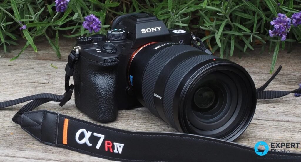 Sony A7R IV avec objectif Sony FE 24-70 GM, posé sur une planche bois, sangle brodée α 7R IV au premier plan