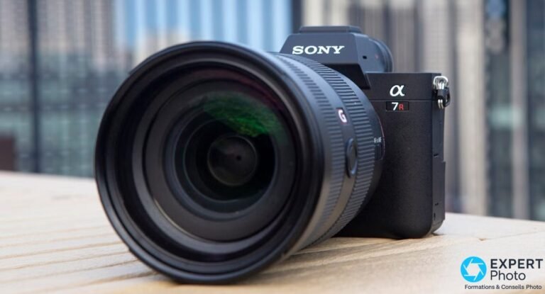 Test Sony A7R IV : haute définition, vidéo en retrait, occasion à privilégier Sony A7R IV équipé d'un objectif Sony G grand-angle, lentille frontale visible, fond urbain flou