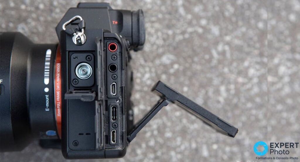 Sony A7R IV vu de profil gauche, volet latéral ouvert sur les prises micro, casque et les ports numériques