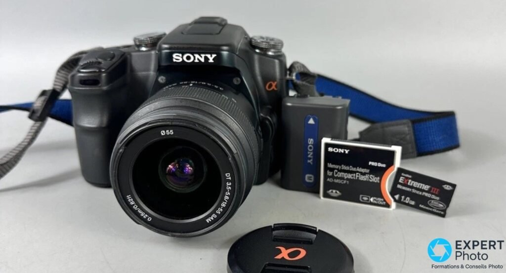 Sony Alpha 100 avec objectif DT 18-55 mm SAM, batterie NP-FM55H, adaptateur Memory Stick vers CompactFlash et bouchon α.