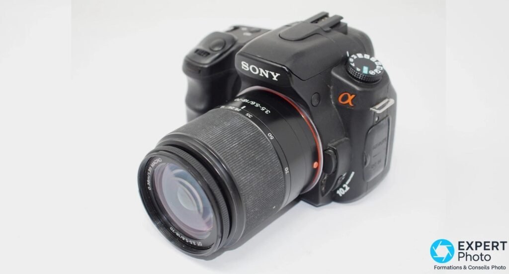 Sony Alpha 200 avec objectif Sony DT 18-70 mm déployé, vue de trois quarts avant droit, mode dial et logo α visibles.