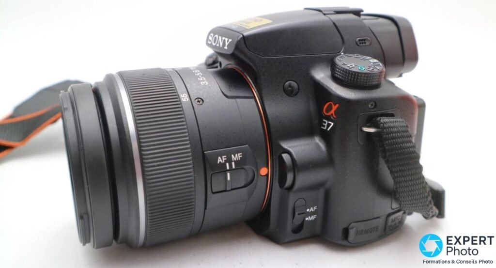 Profil gauche du Sony Alpha 37 (SLT-A37), sélecteurs AF/MF du boîtier et de l'objectif Sony DT 18-55 mm SAM visibles.