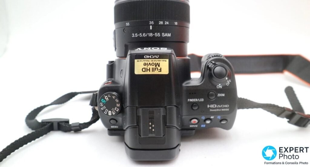 Vue de dessus du Sony Alpha 37 (SLT-A37) avec la molette PASM, la griffe flash et la mention HD AVCHD SteadyShot INSIDE.