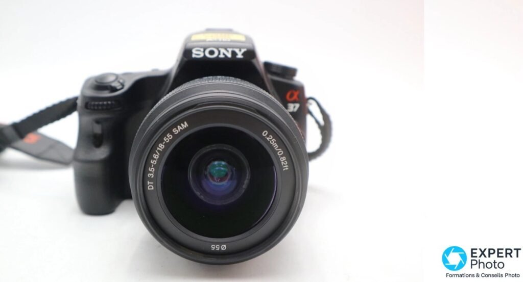 Vue frontale du Sony Alpha 37 (SLT-A37) avec l'objectif Sony DT 18-55 mm SAM, marquage Ø55 et 0.25 m sur la lentille.
