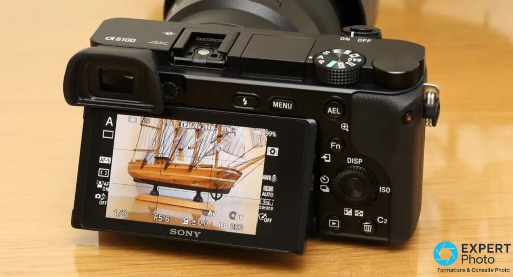 
Sony Alpha 6100 vu de l'arrière, écran inclinable en position basculée affichant une vue en direct (live view).