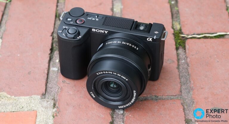 Sony ZV-E10 II noir de trois quarts avant, objectif PZ 16-50mm vers l'avant, posé sur des briques rouges
