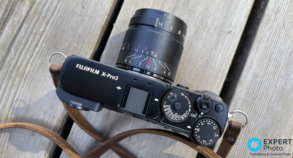 Fujifilm X-Pro3 vu de dessus avec objectif 7Artisans 55mm f/1.4 monté, bague MAP graduée et molettes vitesse ISO du boîtier
