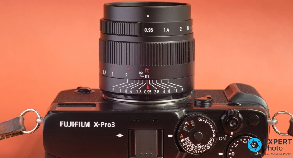 Fujifilm X-Pro3 sur fond orange, objectif 7Artisans monté, bague MAP ft/m et diaphragme 0.95 à 4 visibles de dessus