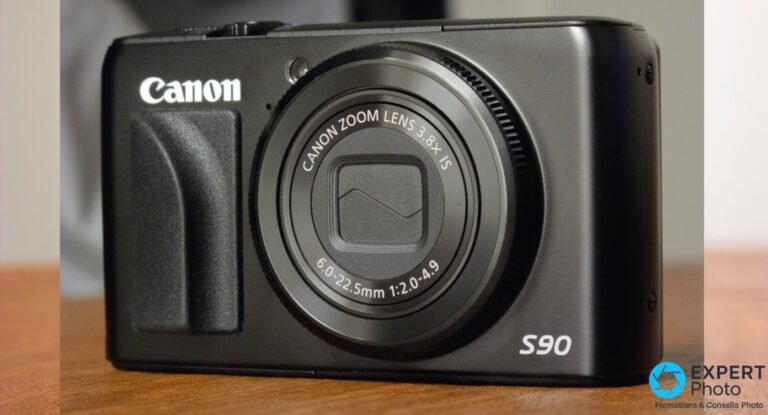 Canon PowerShot S90 de face, objectif Canon Zoom Lens 3.8x IS 6–22,5 mm f/2–4,9 rétracté, logo Canon en haut à gauche