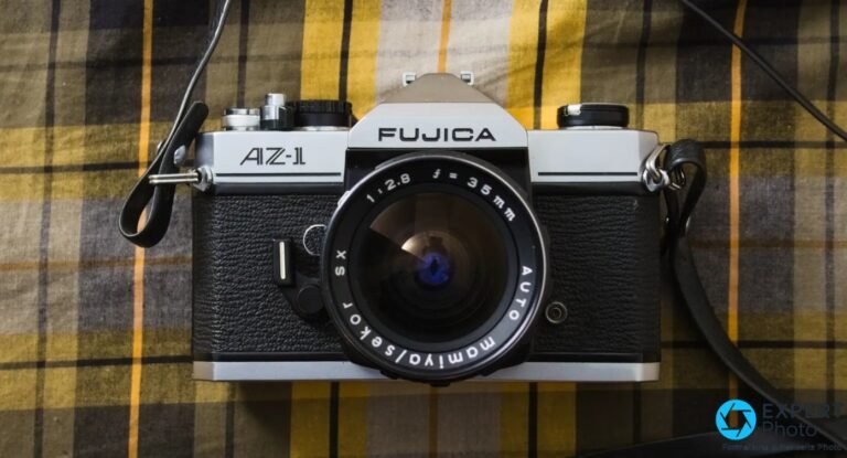 Fujica AZ-1 : reflex M42 à priorité ouverture, avis occasion Fujica AZ-1 de face, objectif Auto Mamiya/Sekor SX 35mm f/2.8 monté, sangle noire, tissu à carreaux jaune