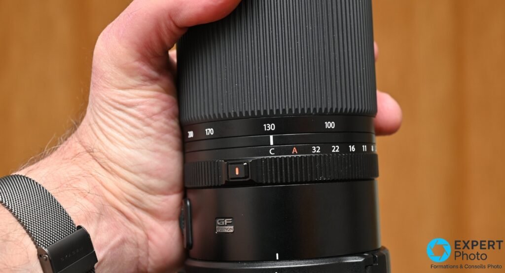 Gros plan sur les bagues de zoom (100-200 mm) et d'ouverture (C A 32 22 16 11) du Fujinon GF 100-200mm, logo GF Fujinon visible