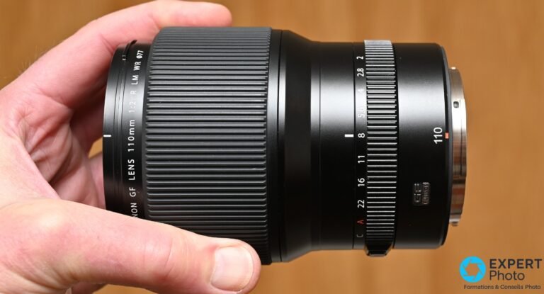 Fujifilm GF 110mm f/2 R LM WR : pour les portraitistes GFX, pas pour les autres Objectif Fujinon GF 110mm f/2 R LM WR en main, vue de profil, bagues de mise au point et diaphragme visibles