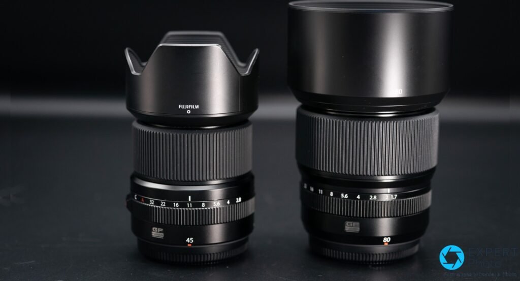 Fujinon GF 45mm (gauche, pare-soleil pétales) et GF 80mm f/1.7 (droite, pare-soleil cylindrique) posés côte à côte