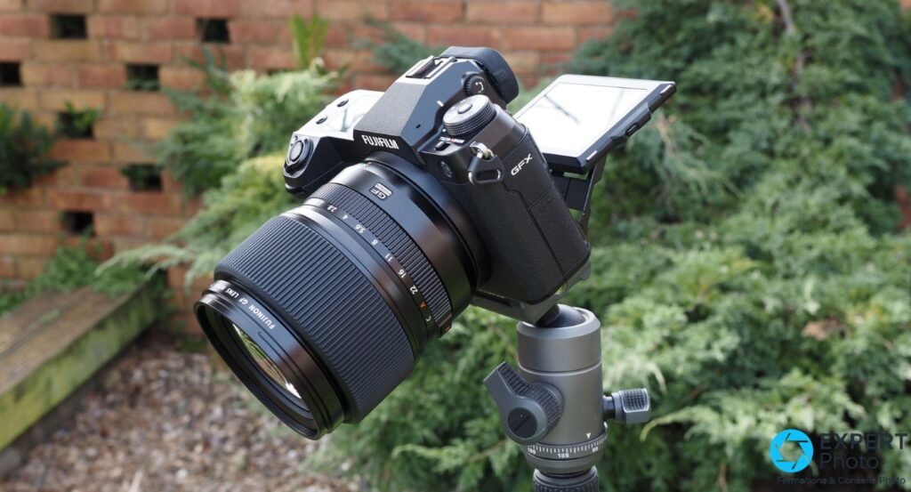 Fujifilm GFX 100S avec écran articulé déployé à 90° vers le haut, objectif Fujinon GF monté, vue 3/4 avant en jardin