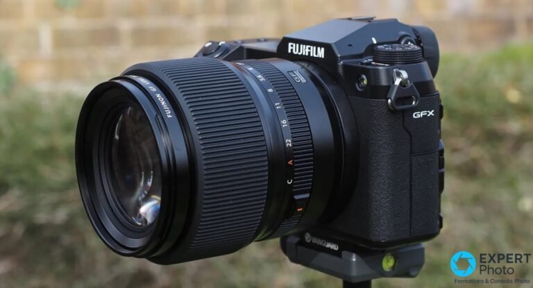 Fujifilm GFX 100S boîtier noir avec objectif Fujinon GF zoom monté, vue 3/4 avant sur trépied Vanguard