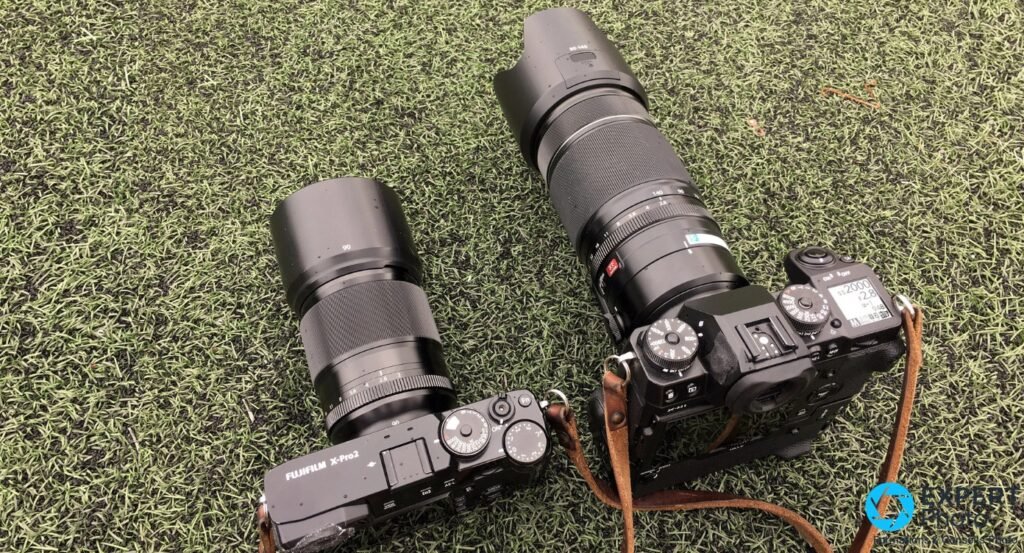 Fujifilm X-Pro2 avec XF 90mm f/2 et pare-soleil à gauche, boîtier Fujifilm avec XF 50-140mm f/2.8 à droite, sur gazon