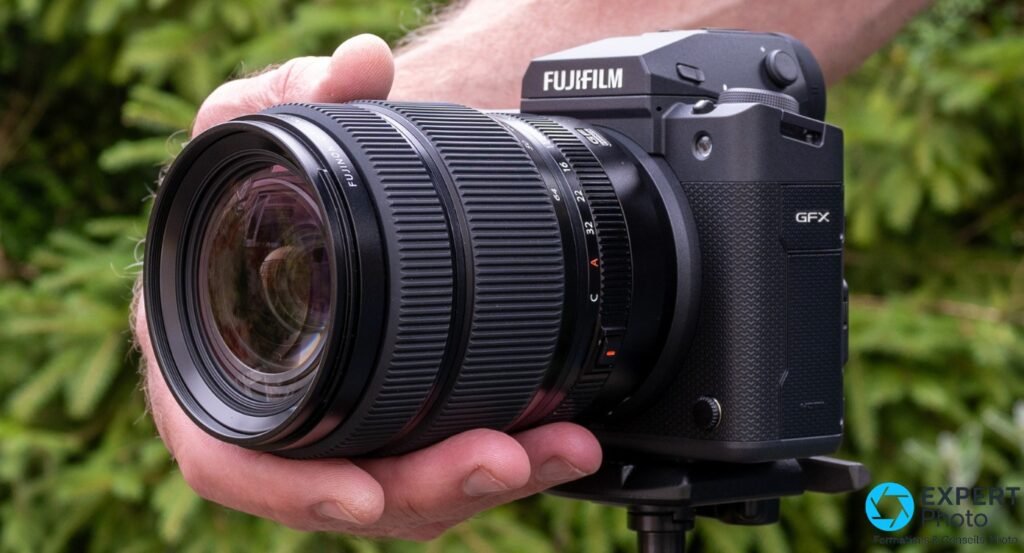 Fujinon GF 32-64mm F4 R LM WR monté sur boîtier Fujifilm GFX, vue 3/4 avant, élément frontal et inscription FUJIFILM lisibles
