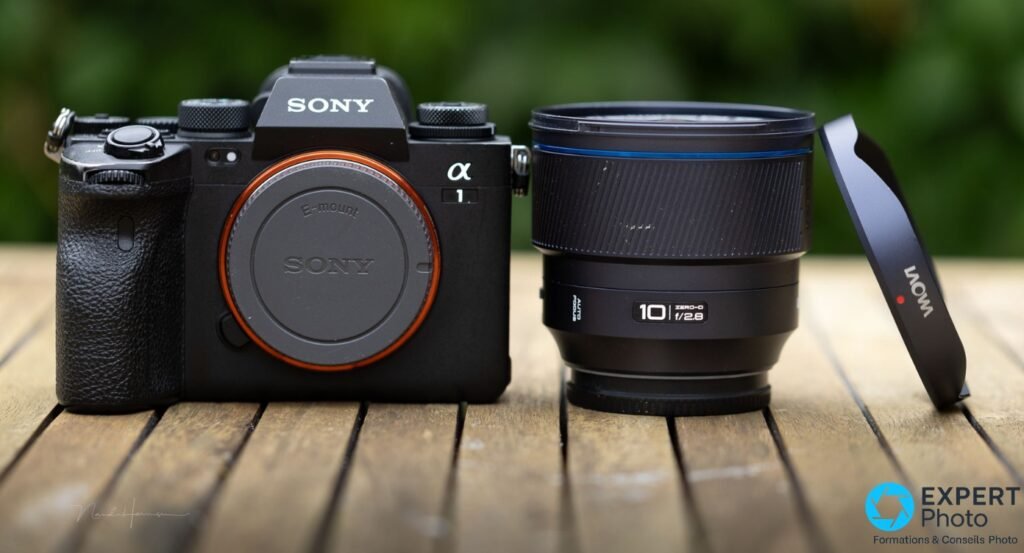 Sony Alpha 1 noir face avant bouchon E-mount, à côté du Laowa 10mm f/2,8 Zero-D debout, bouchon arrière Laowa appuyé contre lui