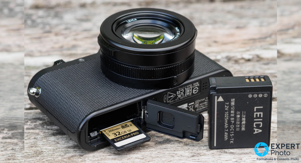 Leica D-Lux 8 compartiment bas ouvert, carte SD Exceria Pro 32 Go visible, batterie Leica BP-DC15-TK sortie à droite