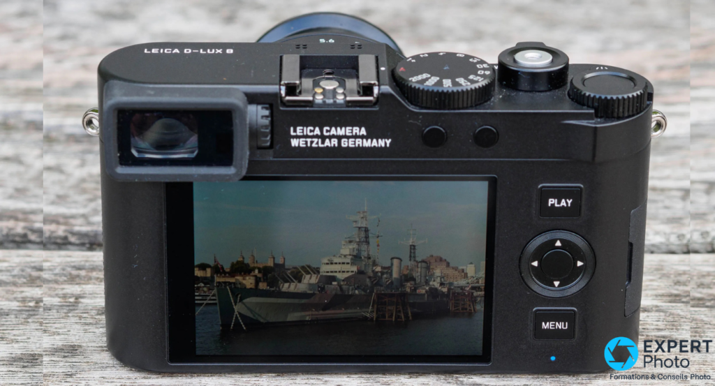 Leica D-Lux 8 dos, écran LCD fixe allumé avec image de port, boutons PLAY MENU et molette navigation noire visibles
