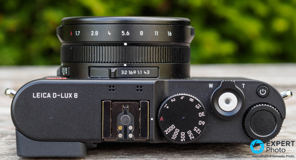 Leica D-Lux 8 vue plongée dessus, bague ouverture A-1.7-2.8-4-5.6-8-11-16, sélecteur 3:2 16:9 1:1 4:3, molette vitesse