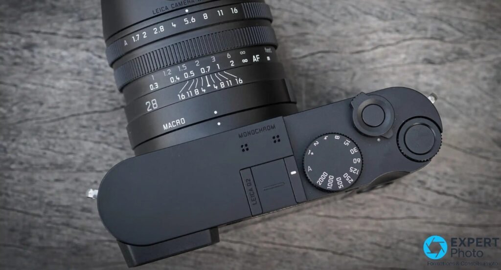 Vue de dessus du Leica Q2 Monochrom, inscriptions LEICA Q2 et MONOCHROM lisibles, molettes ISO et vitesse.