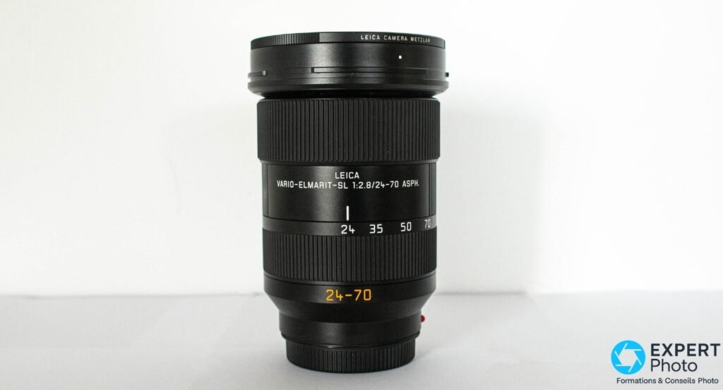 Leica Vario-Elmarit-SL 24-70mm f/2.8 ASPH debout vue de face, inscription et repères focales 24-35-50-70 lisibles, baïonnette L-Mount 