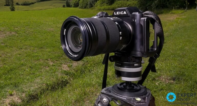 Leica 24-90mm f/2.8-4 sur boîtier Leica SL noir monté sur trépied, extérieur prairie verte, bague zoom visible