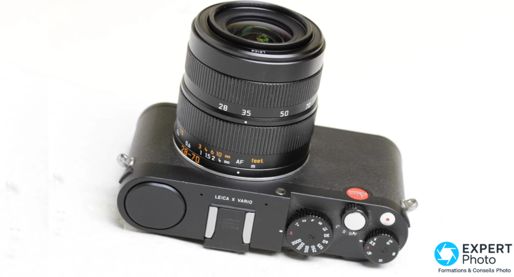 Leica X Vario Typ 107 vu du dessus, bague de focales 28-70 mm, molettes et déclencheur visibles, fond blanc