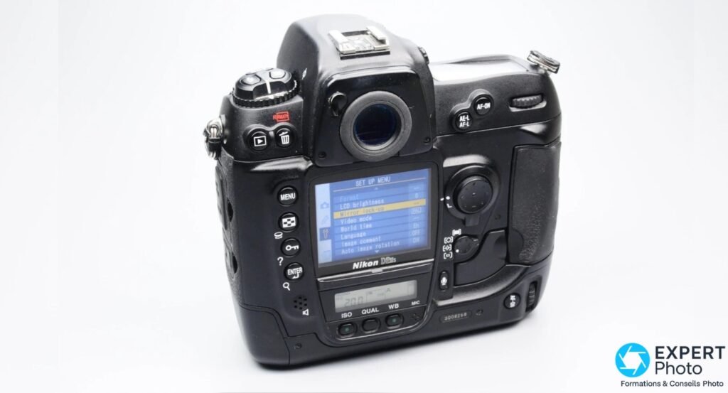 Nikon D2Hs, face arrière, écran LCD allumé affichant un menu de réglages, boutons MENU et ENTER visibles, fond blanc