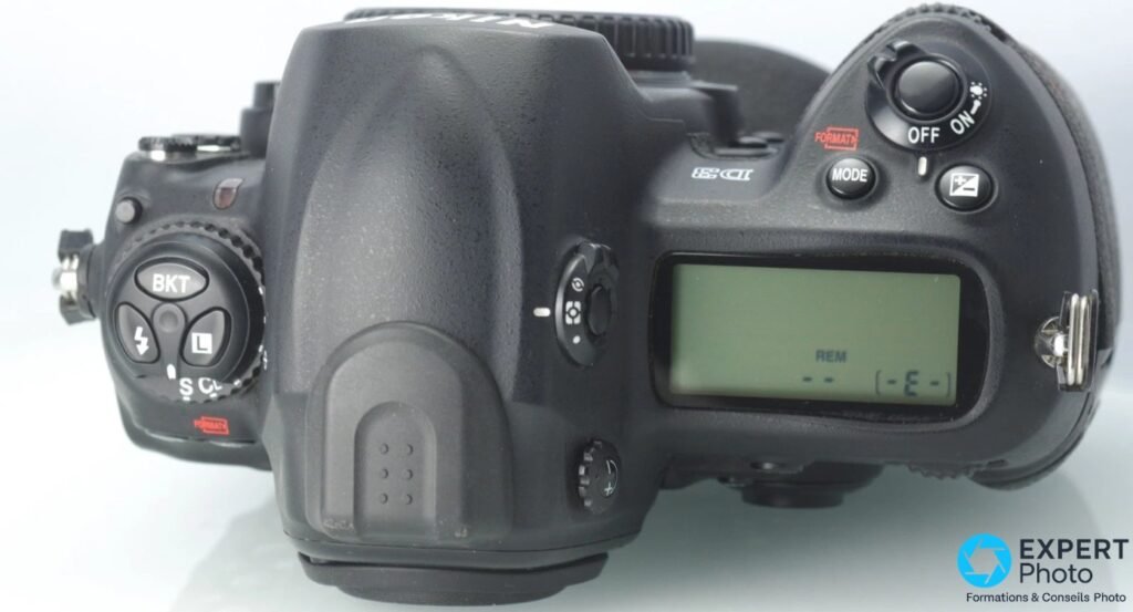 Dessus du Nikon D3, LCD supérieur allumé affichant REM, molette OFF/ON, bouton MODE, marquages BKT et FORMAT en rouge