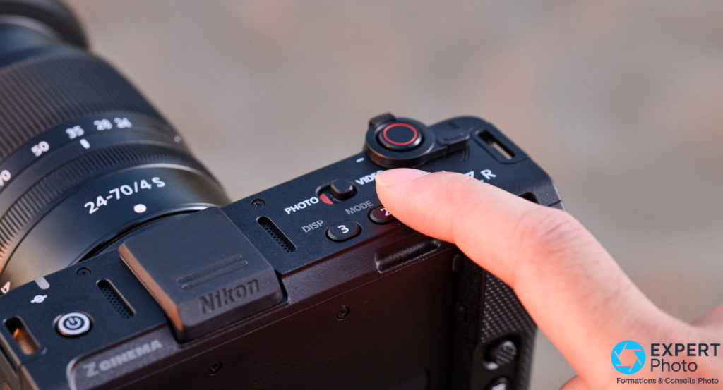  Gros plan boutons PHOTO VIDEO MODE du Nikon ZR, index pointant les commandes, inscription Z CINEMA visible en bas