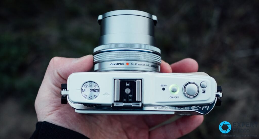  Olympus Pen E-P1 blanc vu du dessus, inscription OLYMPUS PEN Since1959 E-P1 lisible, molette de modes M/A/S/P visible