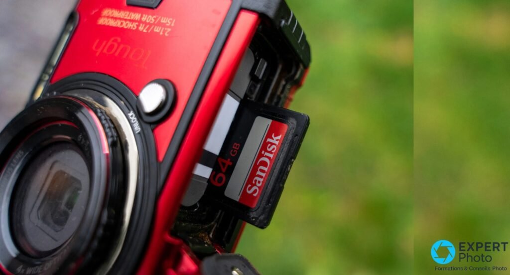 Trappe latérale TG-6 rouge ouverte, carte SD SanDisk 64 Go partiellement éjectée, objectif et verrou UNLOCK visibles